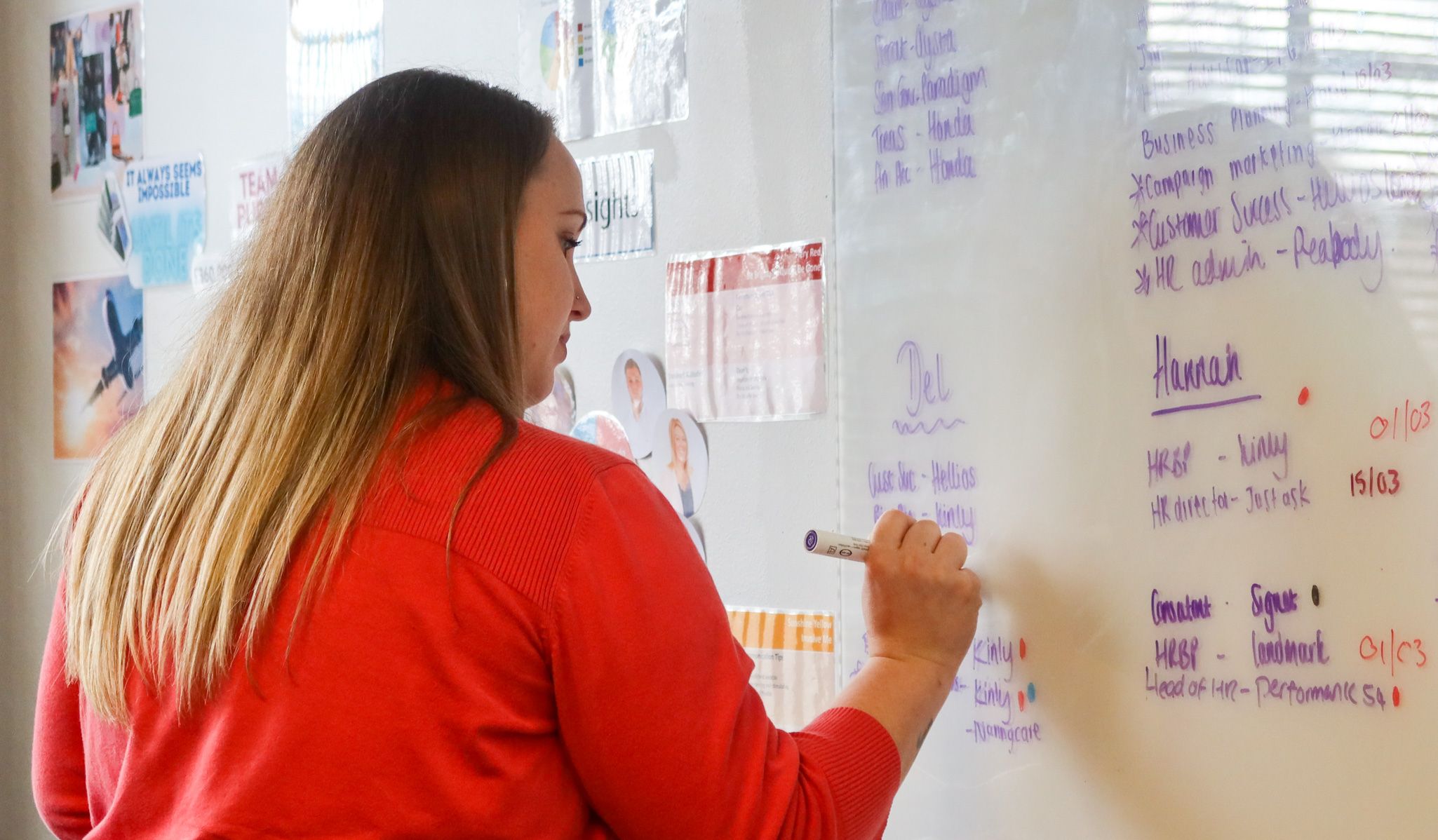 A Signet Recruitment and Retention team member brainstorming recruitment strategies on a whiteboard, fostering a collaborative and innovative work environment.