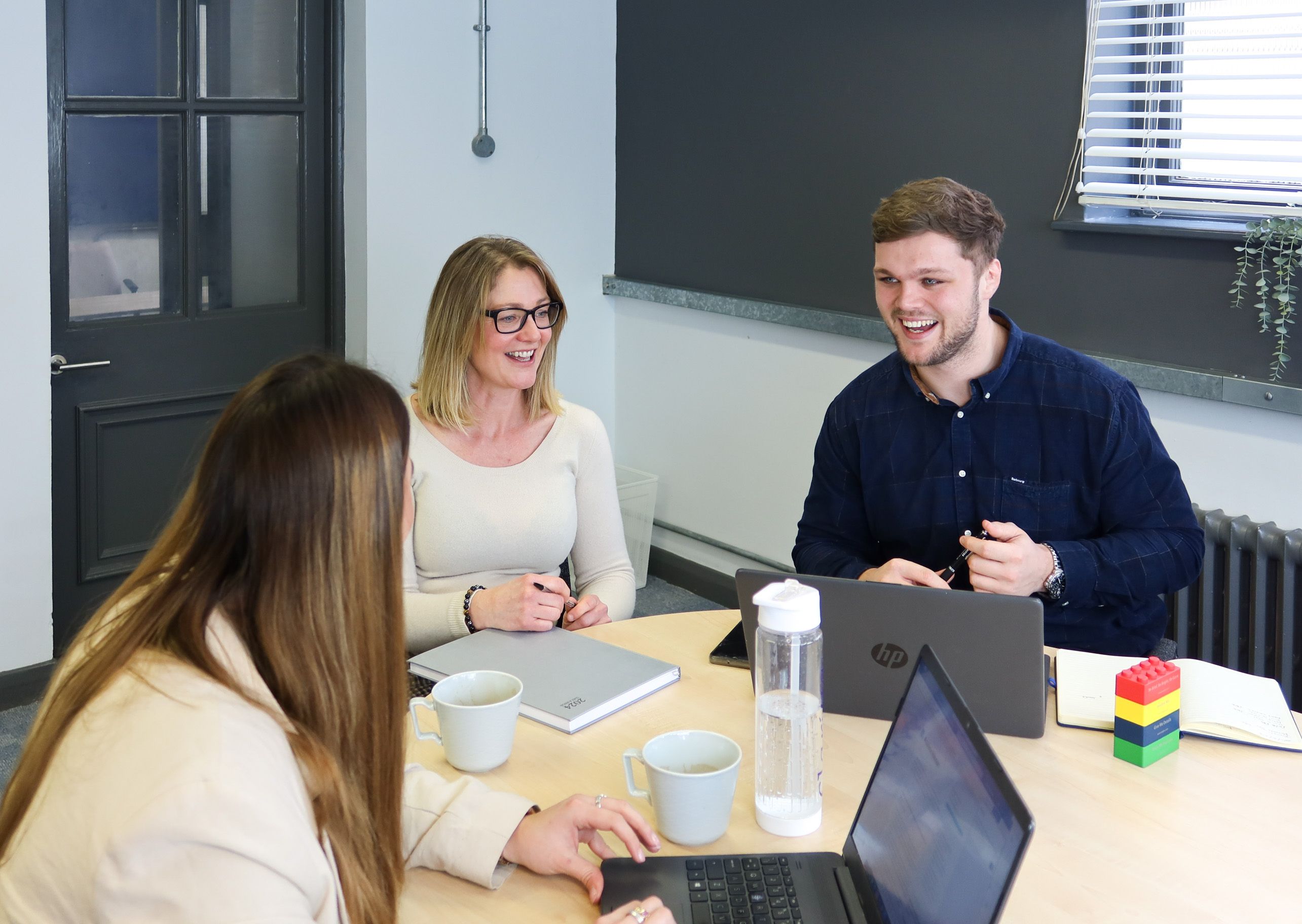 A Signet Recruitment and Retention team member brainstorming recruitment strategies on a whiteboard, fostering a collaborative and innovative work environment.