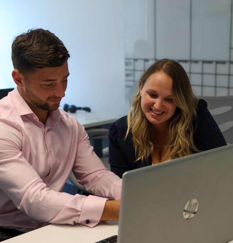 Signet Resources staff member viewing a presentation slide about team passion and enjoyment on a laptop, emphasising a positive work culture.