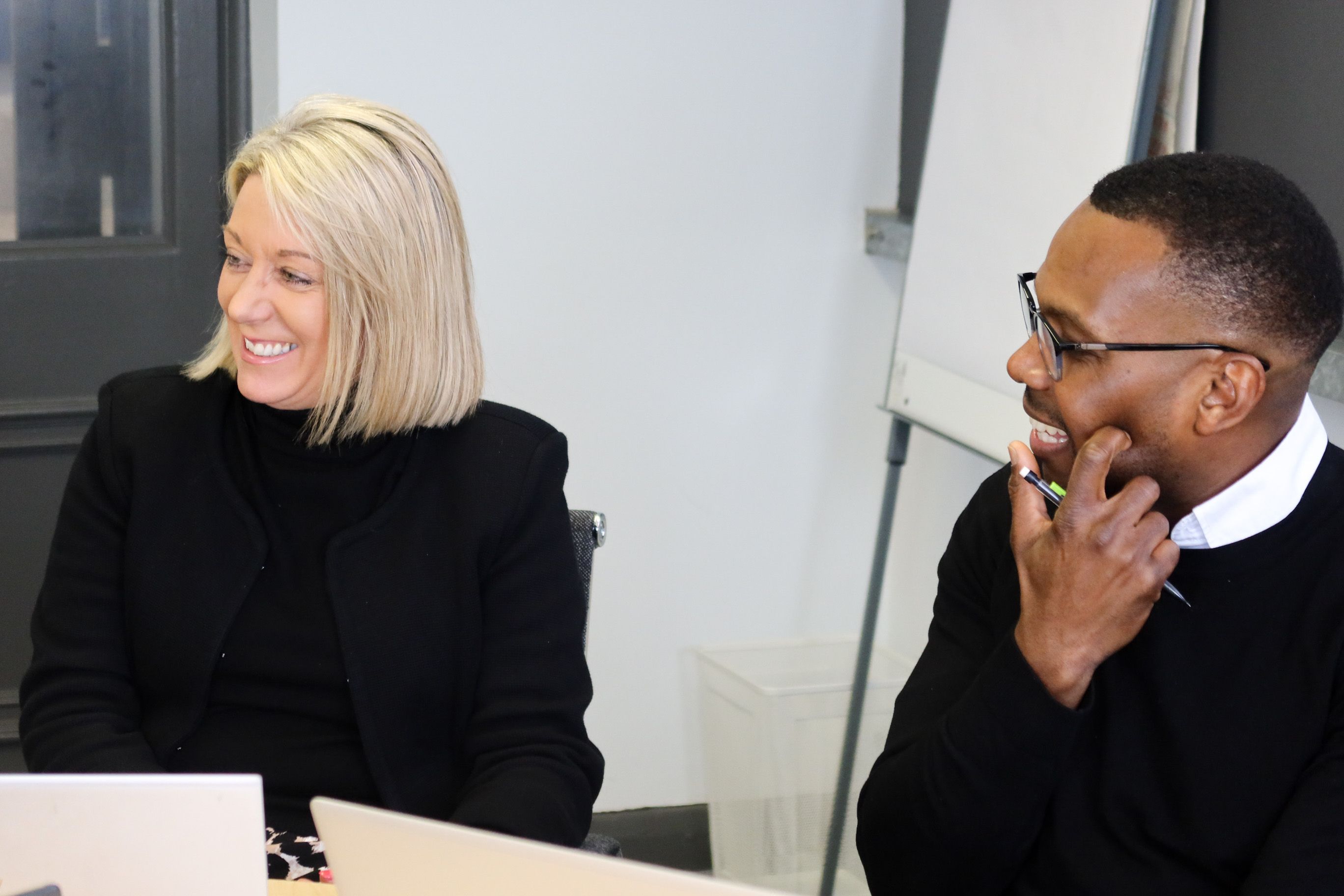 Colleagues at Signet Recruitment and Retention share a moment of connection, reflecting a positive collaborative atmosphere in their recruitment tasks.