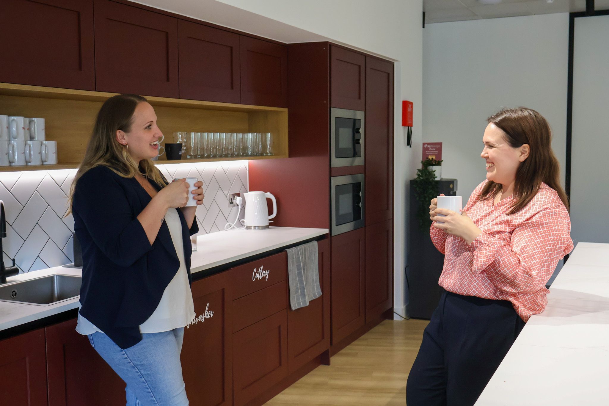 Signet Resources employee reviews recruitment data on a laptop while taking notes, highlighting a multitasking work environment.