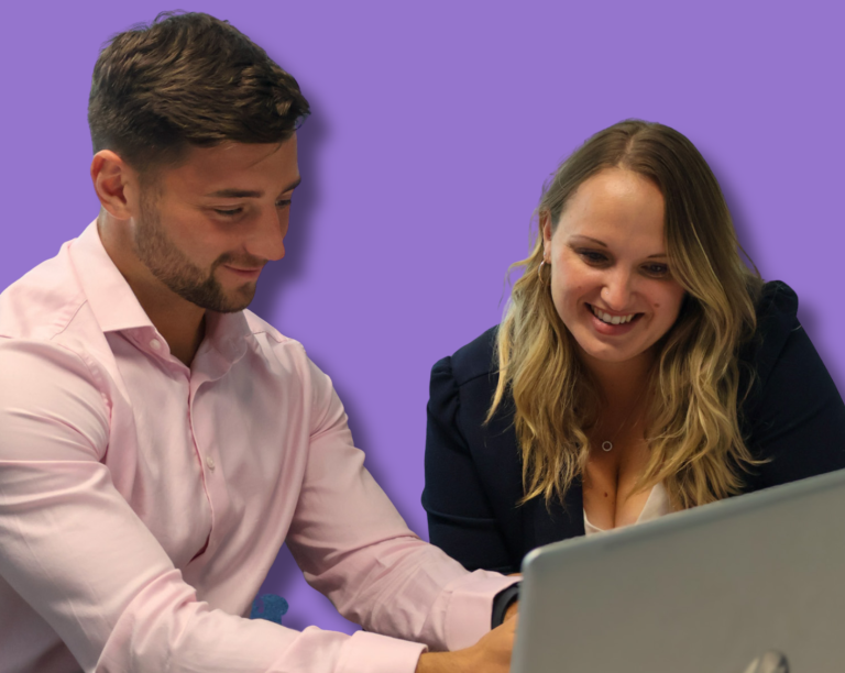 Signet Resources employee reviews recruitment data on a laptop while taking notes, highlighting a multitasking work environment.