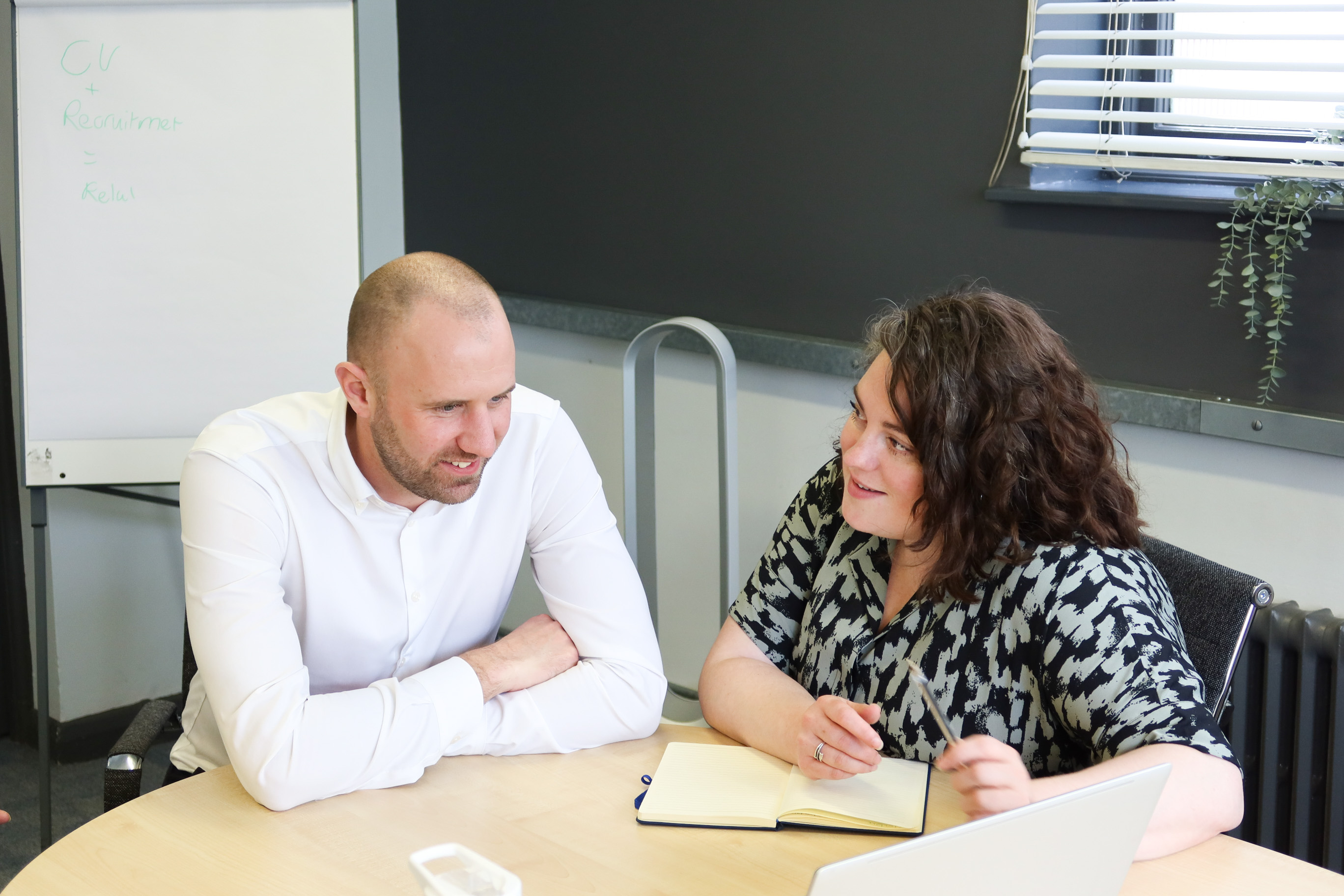 Signet Recruitment and Retention consultants collaborate on CV strategies for recruitment, conveying a relaxed yet focused work atmosphere.