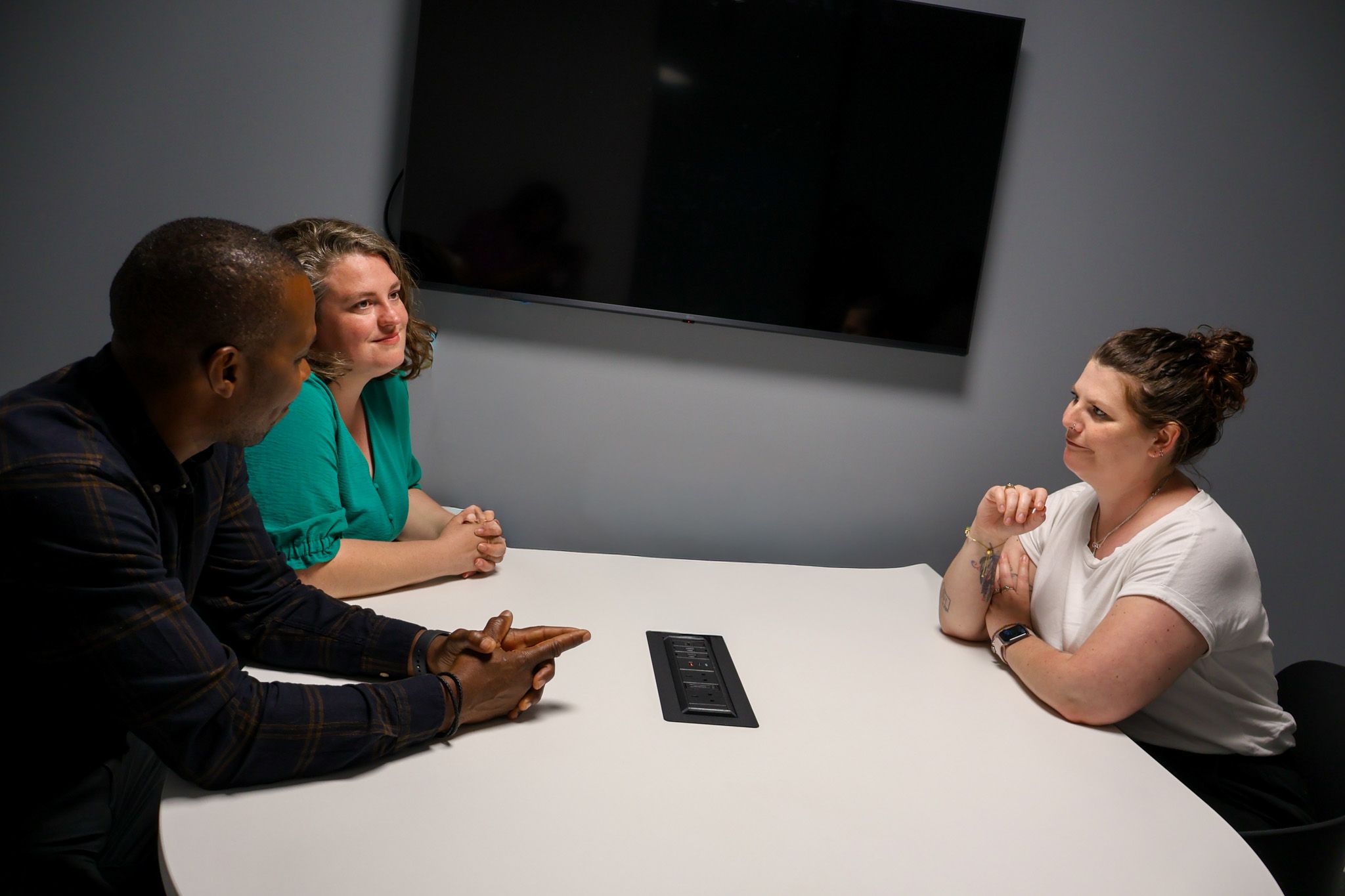 Signet Resources recruitment team engaged in a discussion around a table, with a whiteboard outlining key points in the background.