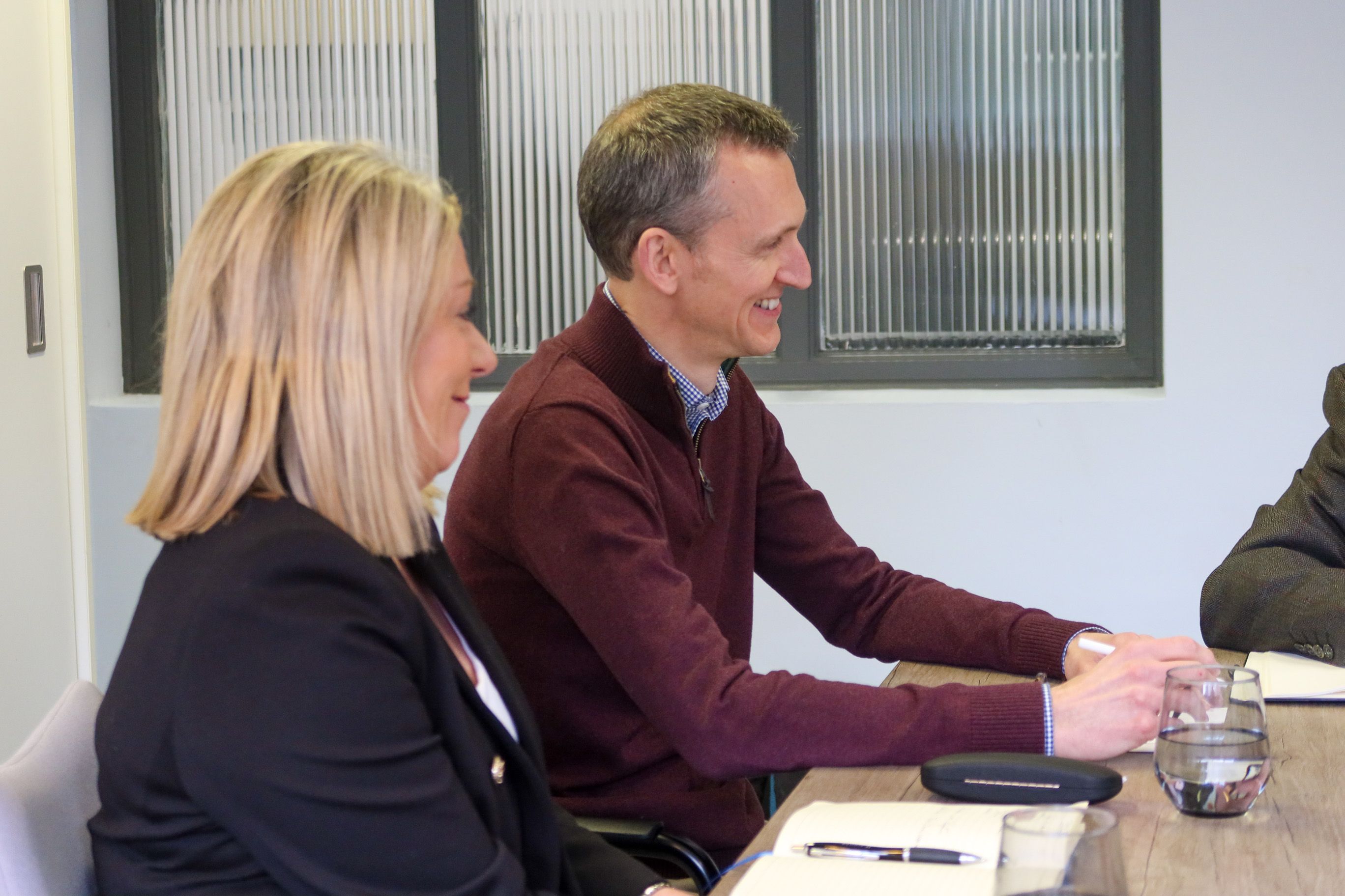 Signet Resources executives in a meeting, exhibiting enthusiasm and engagement in their recruitment discourse.