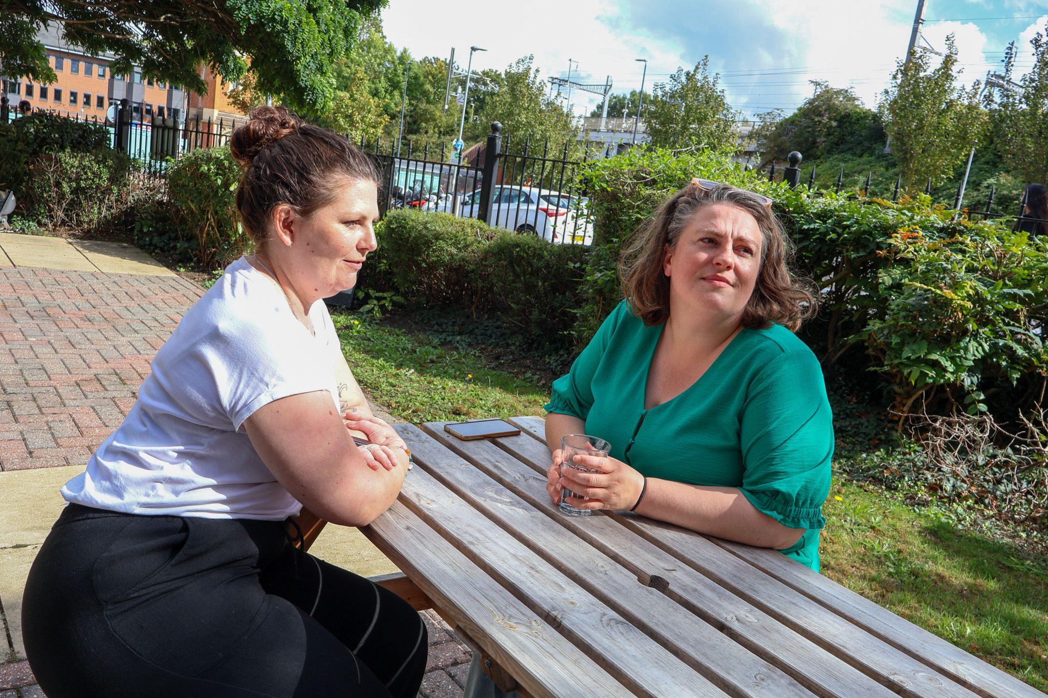 A Signet Resources team member shares insights from a notebook with a smiling colleague, enhancing their recruitment approach.