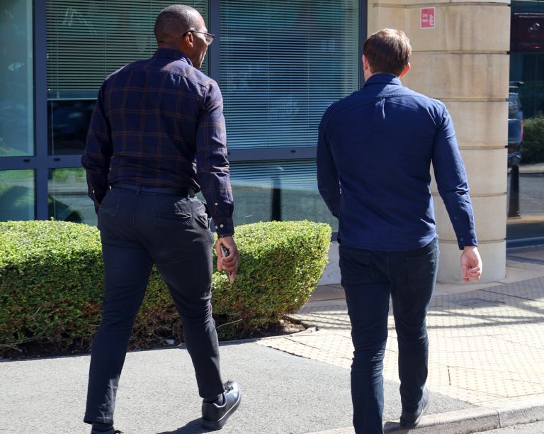 A Signet Resources team member shares insights from a notebook with a smiling colleague, enhancing their recruitment approach.