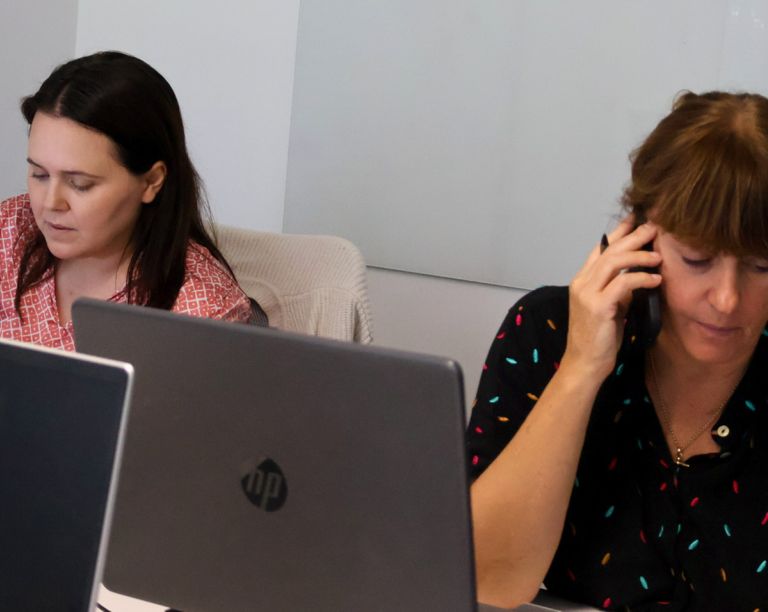 Signet Resources recruitment team engaged in a discussion around a table, with a whiteboard outlining key points in the background.