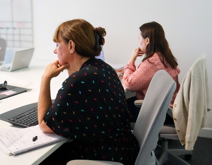 Signet Resources recruitment team engaged in a discussion around a table, with a whiteboard outlining key points in the background.