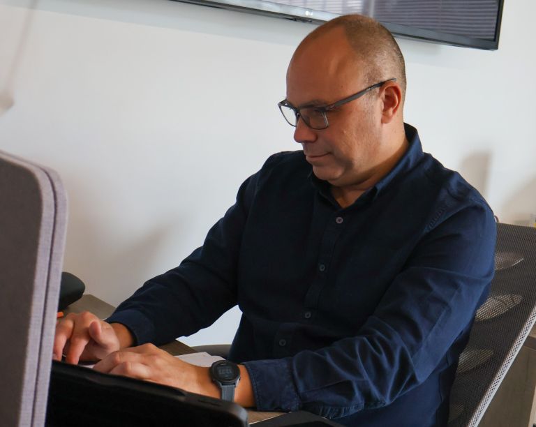 A Signet Resources team member shares insights from a notebook with a smiling colleague, enhancing their recruitment approach.